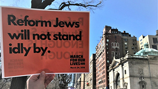 Sign saying “Reform Jews will not stand idly by.”